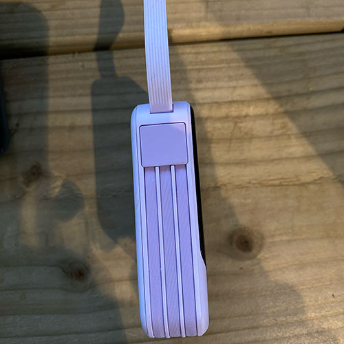 top view of a purple poower bank that shows the charging port and flashlight funtion