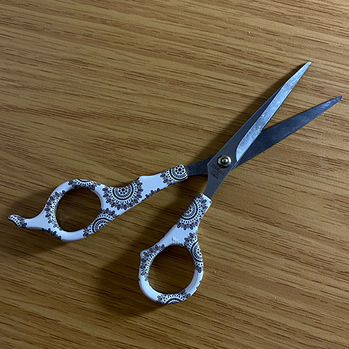 zoomed out full scale picture of hair scissors with flower print on the handle